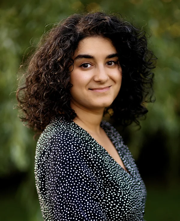 Kobieta z półprofilu o ciemnych oczach i kręconych, ciemnych włosach