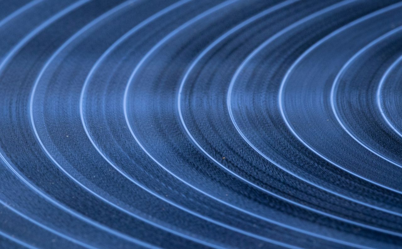 Grafika przestawia fragment płyty winylowej.