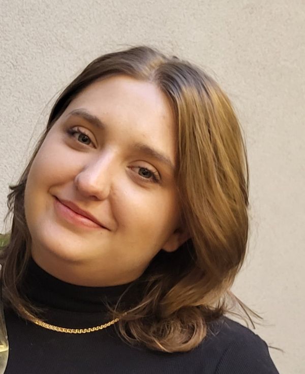 Portret uśmiechniętej kobiety w czarnym golfie.