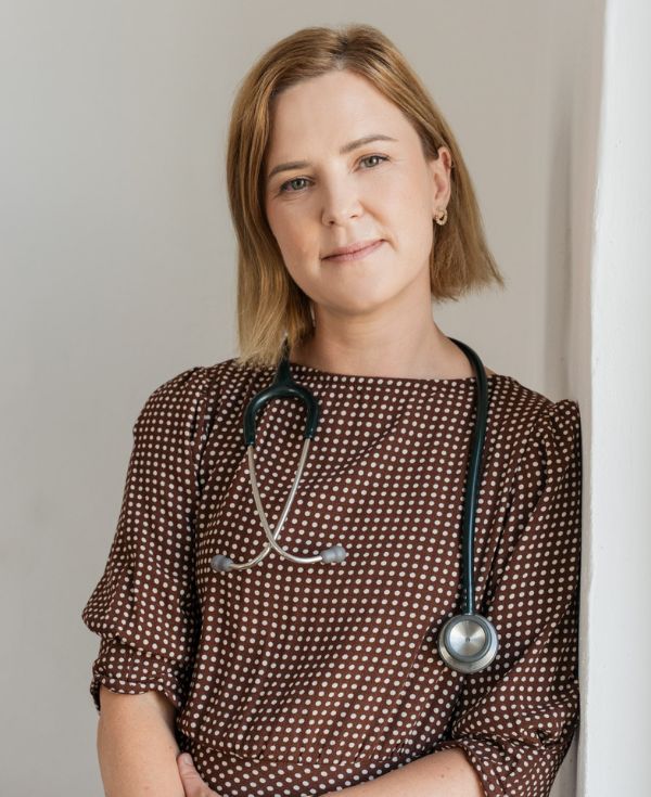 Blondynka w brązowej sukience ze stetoskopem zawieszonym na szyi