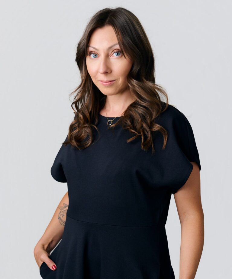 Sylwetka kobiety z włosami za ramiona i granatowej sukience