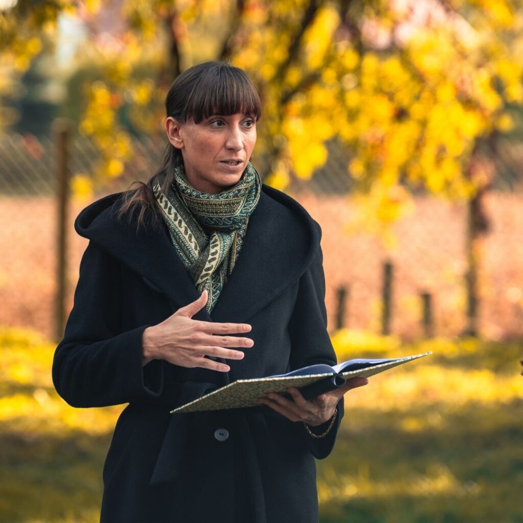 Kobieta w płaszczu z otwartym notatnikiem