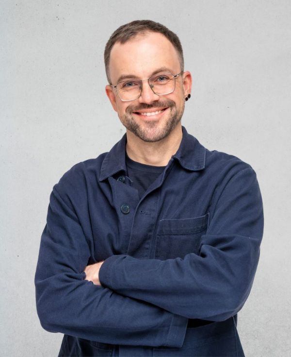 Uśmiechnięty mężczyzna w okularach, w granatowej koszuli