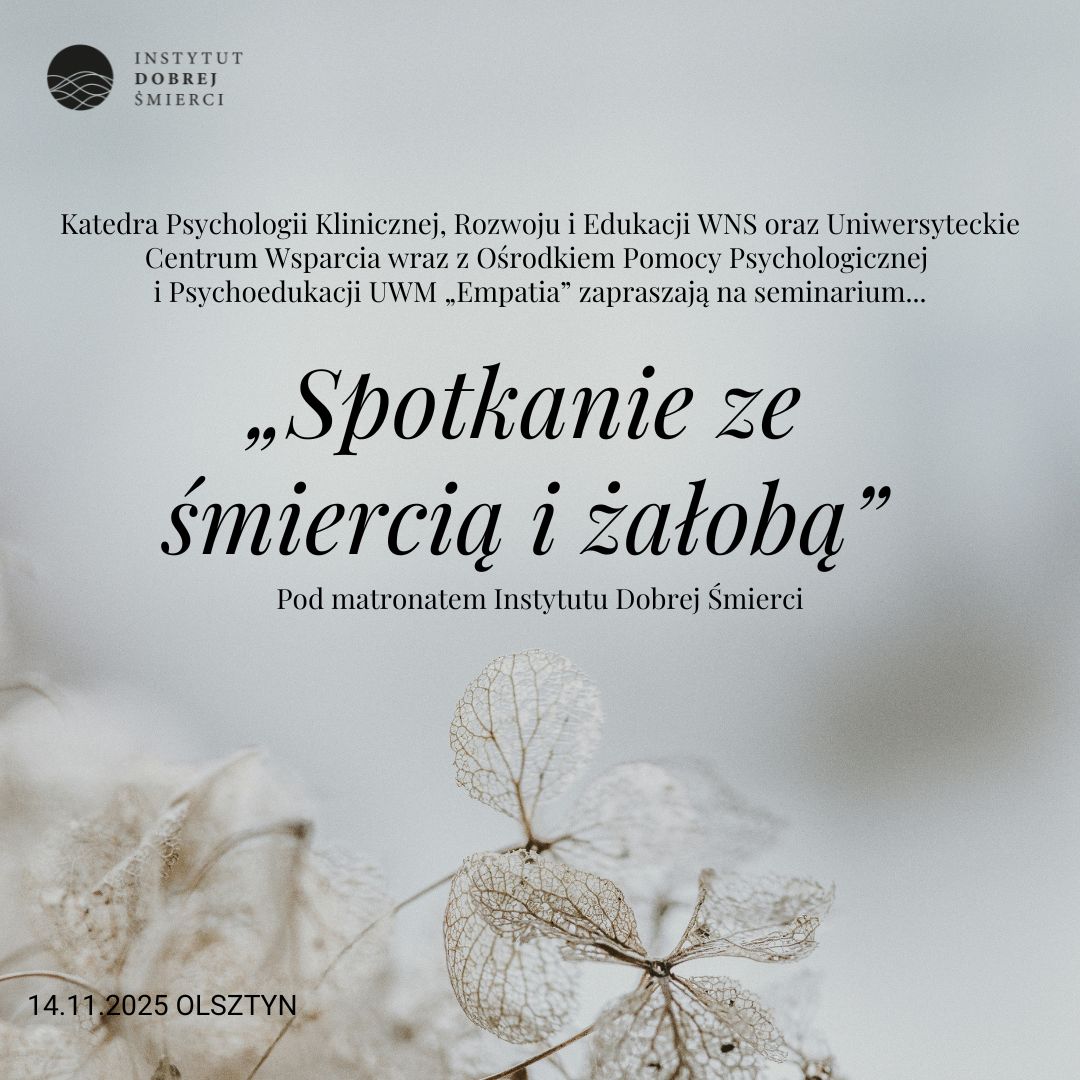 Czarny napis na szarym tle i białe, suszone kwiaty
