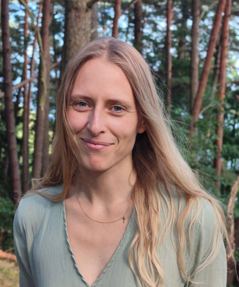 Portretowe zdjęcie kobiety w zielonej sukience i blond włosach