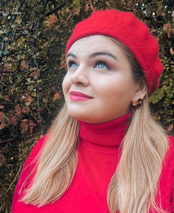 Kobieta o blond włosach, w berecie i golfie.